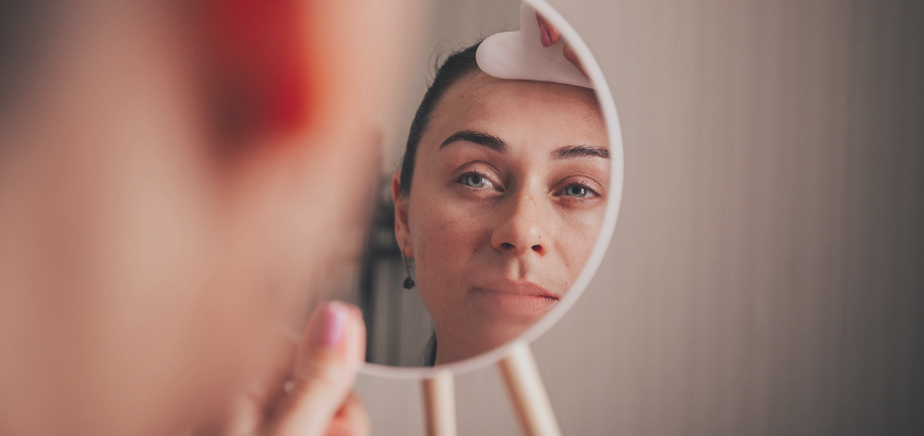 Стереть с лица морщины и усталость Девушка смотрит в зеркало