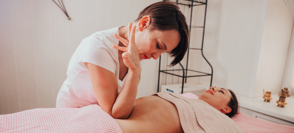 Массажист проминает локтем низ живота