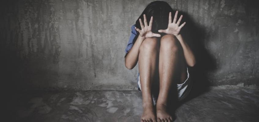 Девушка сидит на полу в темной комнате