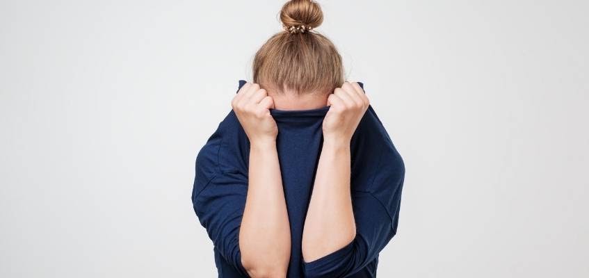 Девушка закрыла лицо кофтой