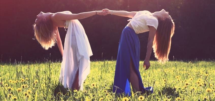 Девушки держаться за руки и наклоняются