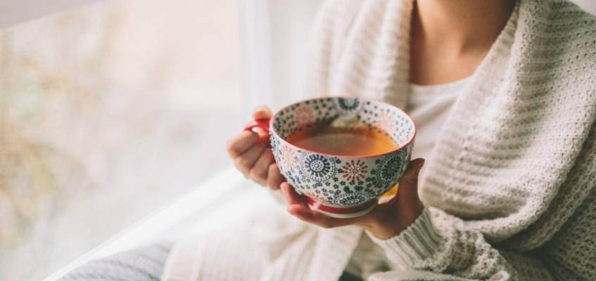 Девушка держит чашку с чаем
