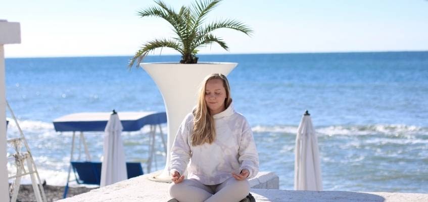 Девушка медитирует на фоне моря