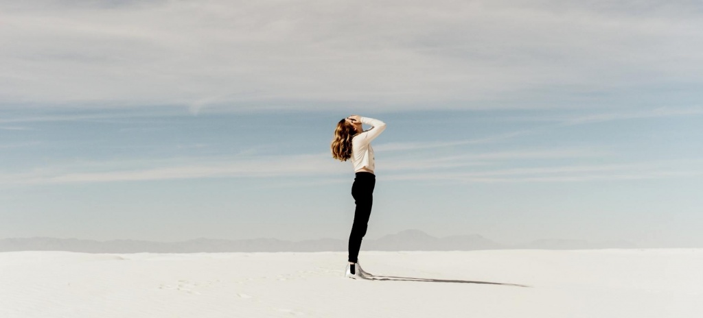 Девушка в пустыни закрывает лицо