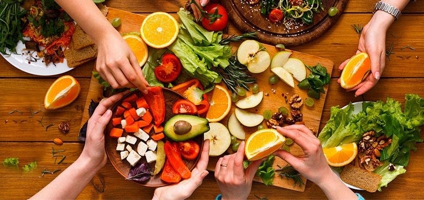 Люди берут фрукты со стола