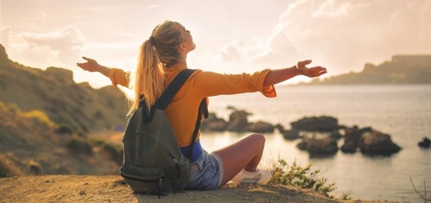 Девушка сидит с распростёртыми руками